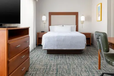a hotel room with a bed and a flat screen tv at Homewood Suites by Hilton Ontario Rancho Cucamonga in Rancho Cucamonga