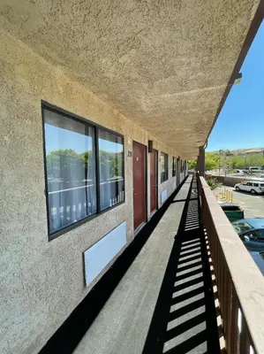 an empty corridor of a building with windows at Palms Inn & Suites in Palmdale
