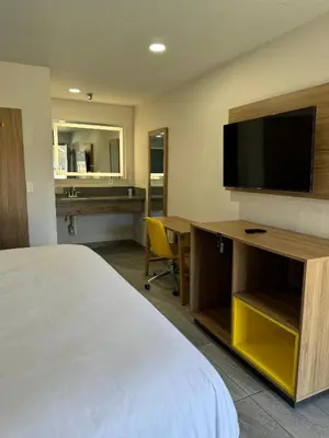 a hotel room with a bed and a flat screen tv at Days-Inn by Wyndham Bakersfield in Bakersfield
