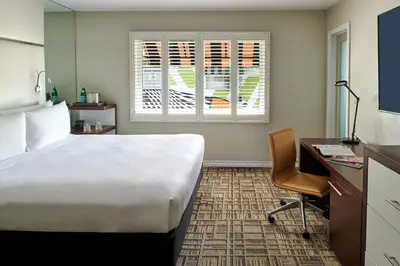 a hotel room with a bed and a desk and a window at Hotel Ziggy On Sunset in Los Angeles