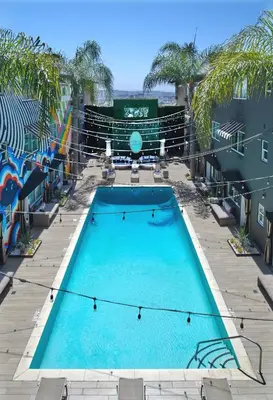 a large swimming pool in a courtyard with palm trees at Hotel Ziggy On Sunset in Los Angeles