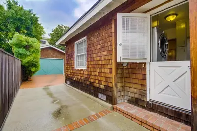 a brick house with a white door and a garage at A Touch of Cape Cod in West Hollywood in Los Angeles
