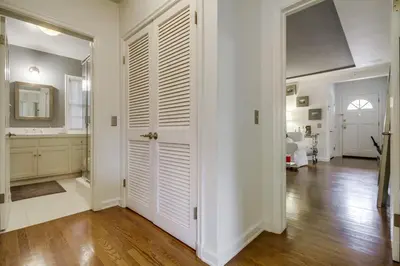 a hallway with a white door and a bathroom at A Touch of Cape Cod in West Hollywood in Los Angeles