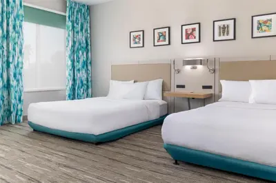 a hotel room with two beds and a desk at Hilton Garden Inn Ontario Rancho Cucamonga in Rancho Cucamonga