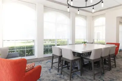 a dining room with a white table and chairs at Hilton Garden Inn Ontario Rancho Cucamonga in Rancho Cucamonga