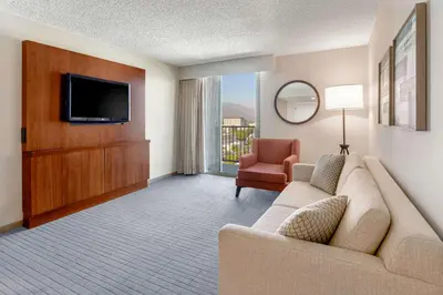 a living room with a couch and a tv and a chair at Hilton Pasadena in Pasadena