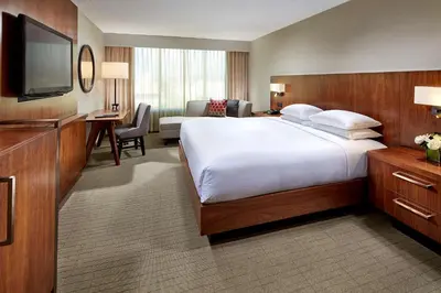 a hotel room with a large bed and a television at Hilton Pasadena in Pasadena