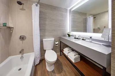 a bathroom with a toilet and a sink and a tub at Hilton Pasadena in Pasadena