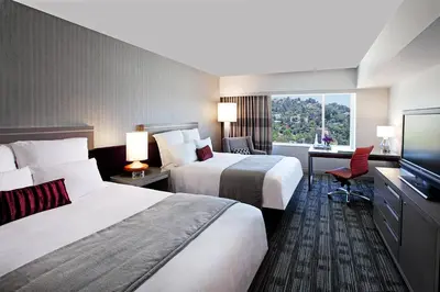 a hotel room with two beds and a flat screen tv at Loews Hollywood Hotel in Los Angeles