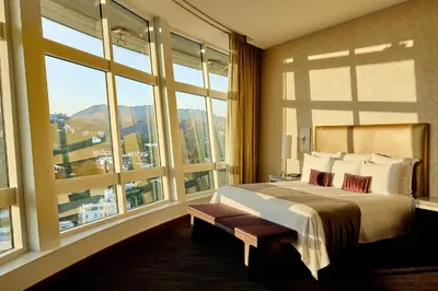 a bedroom with a large bed and large windows at Loews Hollywood Hotel in Los Angeles