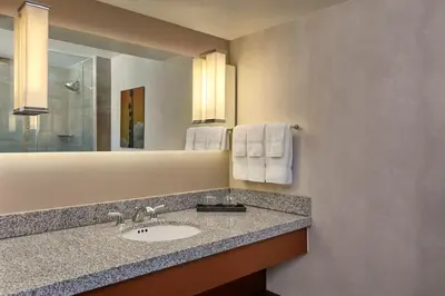a bathroom with a sink and a mirror and towels at Loews Hollywood Hotel in Los Angeles