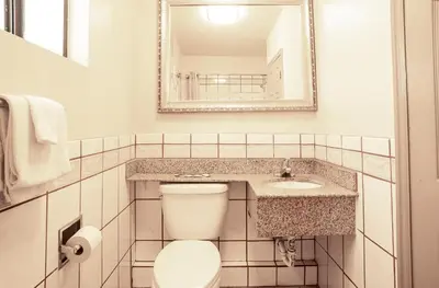 a bathroom with a toilet and a sink and a mirror at Economy Inn Hollywood in Los Angeles