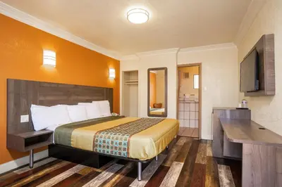 a hotel room with a bed and a bathroom at Economy Inn Hollywood in Los Angeles
