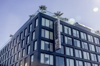 an office building with palm trees on top of it at The Godfrey Hotel Hollywood in Los Angeles