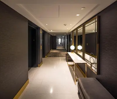 a corridor in a building with benches and mirrors at The Godfrey Hotel Hollywood in Los Angeles