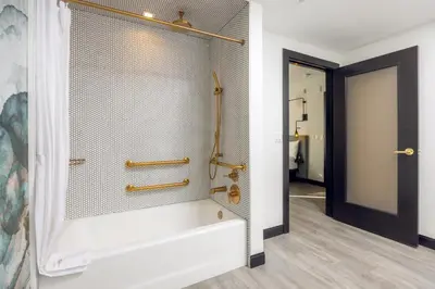a bathroom with a shower with a tub at The Godfrey Hotel Hollywood in Los Angeles