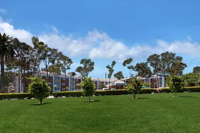 a row of trees in a park in front of a building at Holiday Inn Express Port Hueneme by IHG in Port Hueneme