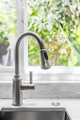 a kitchen sink with a faucet in front of a window at Charming 1-Bedroom Home near Downtown Culver in Los Angeles