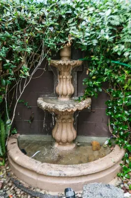 a stone fountain in a garden with plants at Charming 1-Bedroom Home near Downtown Culver in Los Angeles
