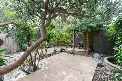 a backyard patio with a tree and a chair at Charming 1-Bedroom Home near Downtown Culver in Los Angeles