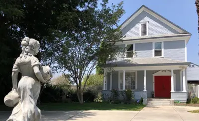 a statue of a girl in front of a house at Cozy Suite near City of hope in Duarte