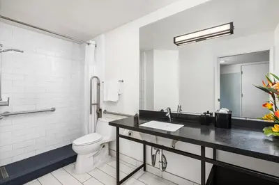 a white bathroom with a toilet and a sink at Hotel Erwin Venice Beach in Los Angeles