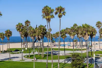 a park with palm trees and the beach at Hotel Erwin Venice Beach in Los Angeles