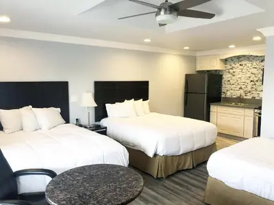 a hotel room with two beds and a kitchen at Crystal Lodge Motel in Ventura