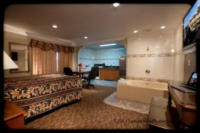 a hotel room with a bed and a bathroom at Crystal Lodge Motel in Ventura