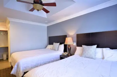 a bedroom with two beds and a ceiling fan at Crystal Lodge Motel in Ventura