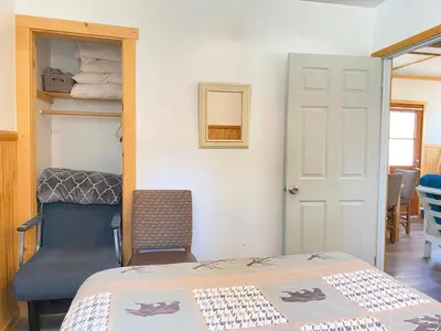 a bedroom with a bed and a chair and a door at Blue Horizon Lodge in Big Bear Lake