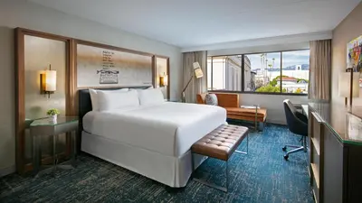 a hotel room with a large white bed and a desk at Hotel Dena, Pasadena Los Angeles, a Tribute Portfolio Hotel in Pasadena
