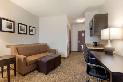 a living room with a couch and a table in a hotel room at Comfort Suites Ontario Airport Convention Center in Ontario