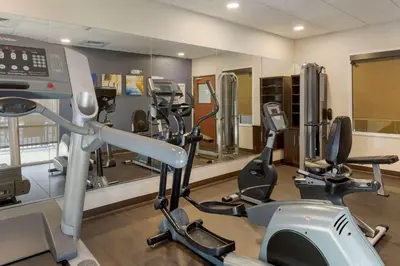 a gym with treadmills and ellipticals in a room at Comfort Suites Ontario Airport Convention Center in Ontario