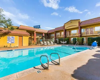 a swimming pool in front of a hotel at Rodeway Inn & Suites Corona in Corona