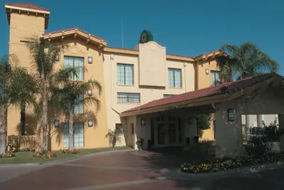 a building with a palm tree in front of it at La Quinta Inn by Wyndham Bakersfield South in Bakersfield