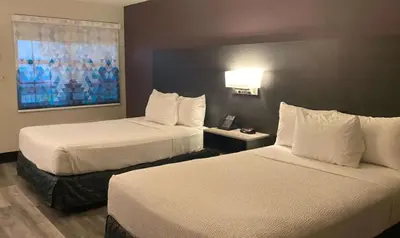 a hotel room with two beds and a telephone at La Quinta Inn by Wyndham Bakersfield South in Bakersfield