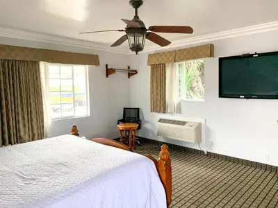 a bedroom with a bed and a flat screen tv at Viking Motel-Ventura in Ventura
