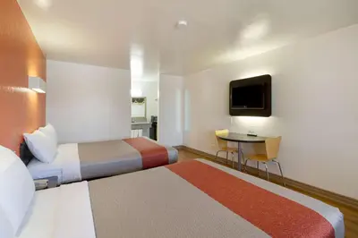 a hotel room with two beds and a table at Motel 6-Claremont, CA in Claremont