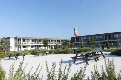 two picnic tables in a park in front of a building at Motel 6-Claremont, CA in Claremont