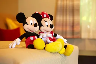 two mickey mouse stuffed animals sitting on a bed at Eden Roc Inn & Suites near the Maingate in Anaheim
