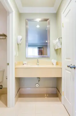 a bathroom with a sink and a mirror at Eden Roc Inn & Suites near the Maingate in Anaheim
