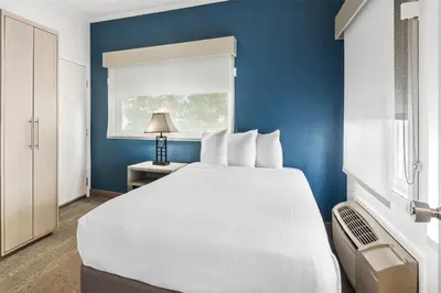 a bedroom with a white bed and a blue wall at SureStay Hotel by Best Western Santa Monica in Los Angeles