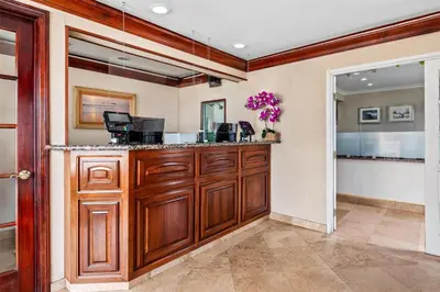 a kitchen with wooden cabinets and a counter at SureStay Hotel by Best Western Santa Monica in Los Angeles