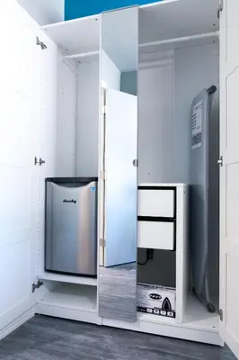 a mirror in a room with a tv and a refrigerator at Tilbury Inn in Glendale
