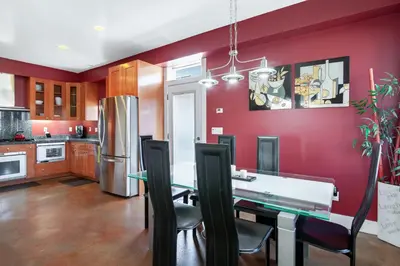 a kitchen with red walls and a dining table and chairs at The Swaying Palm Haaven in Seal Beach