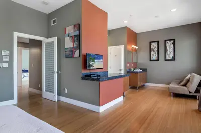 a room with a bed and a living room at The Swaying Palm Haaven in Seal Beach