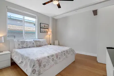 a white bedroom with a bed and a window at The Swaying Palm Haaven in Seal Beach