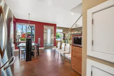 a dining room with a table and a tv at The Swaying Palm Haaven in Seal Beach