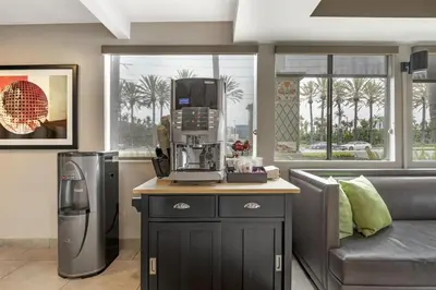 a kitchen with a coffee maker on a counter next to a couch at Best Western Plus Pavilions in Anaheim
